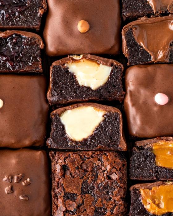 Brownies cobertos de chocolate vistos de cima, com os recheios à mostra