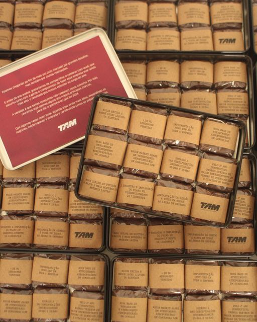 Latas com brownies e cintas impressas com as conquistas do ano da TAM