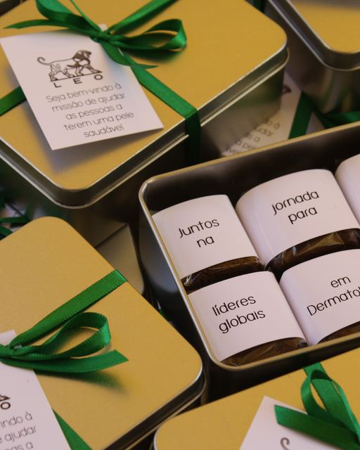 Latas douradas com brownies e cintas personalizadas LEO Pharma